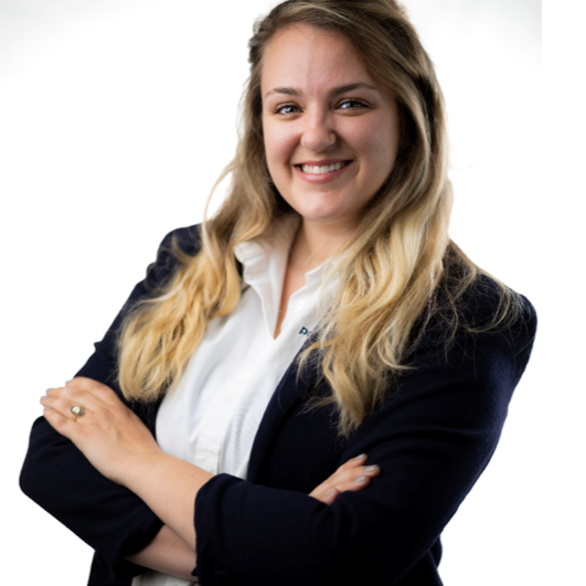 A woman with long blonde hair wearing a white shirt and jacket.